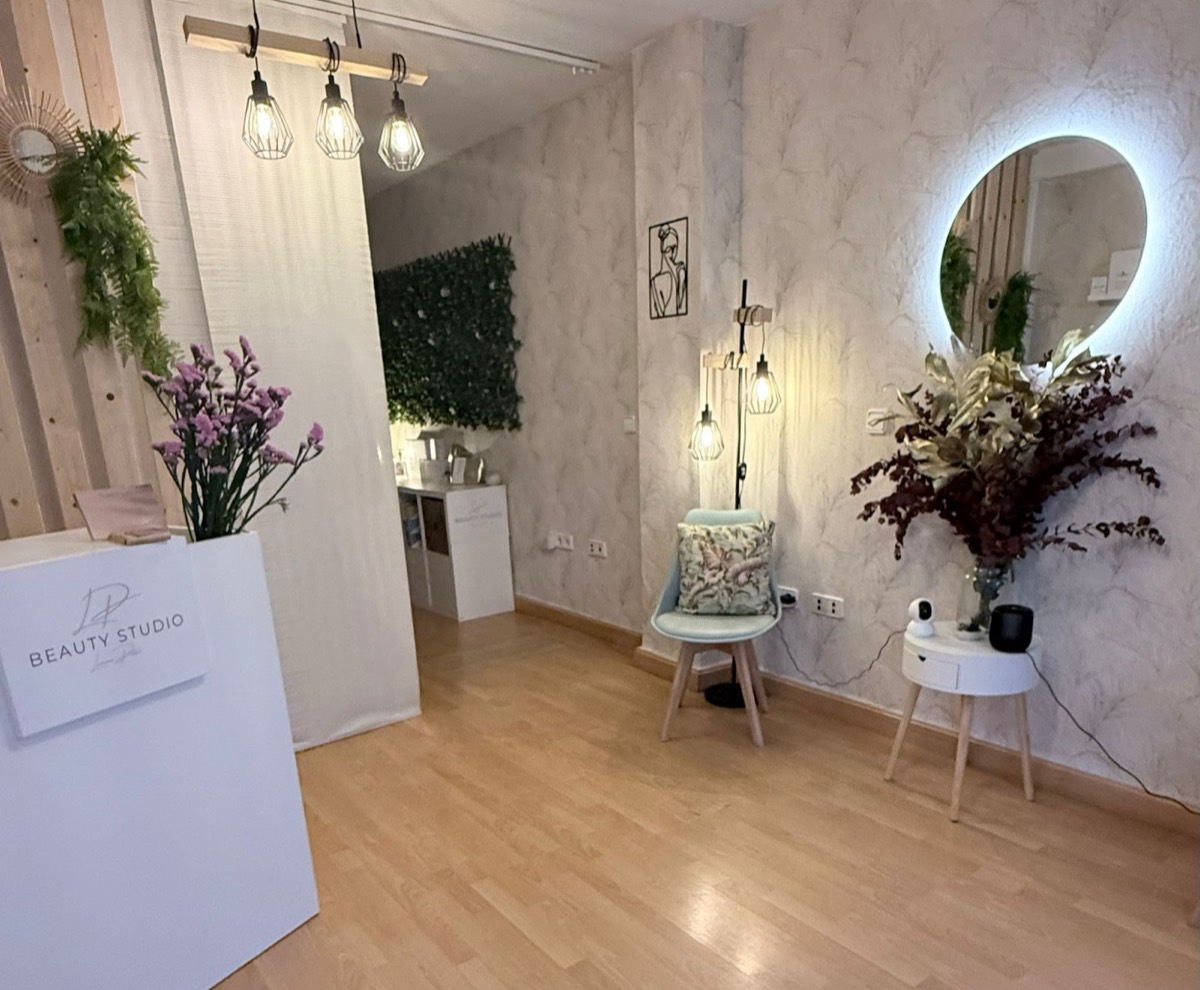 Recepción de LP Beauty Studio con mostrador, lámparas y espejo redondo